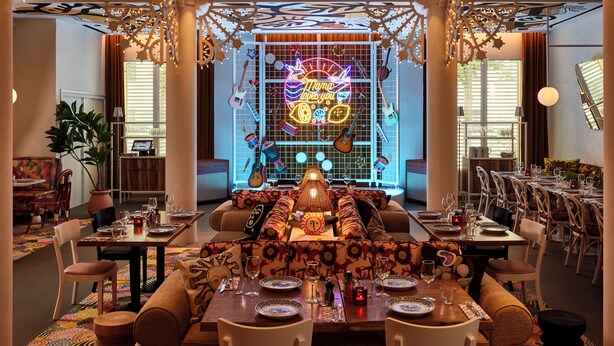 A spacious dining area with a long table set for multiple guests, surrounded by comfortable seating. - Mama Shelter Nice (Nice)