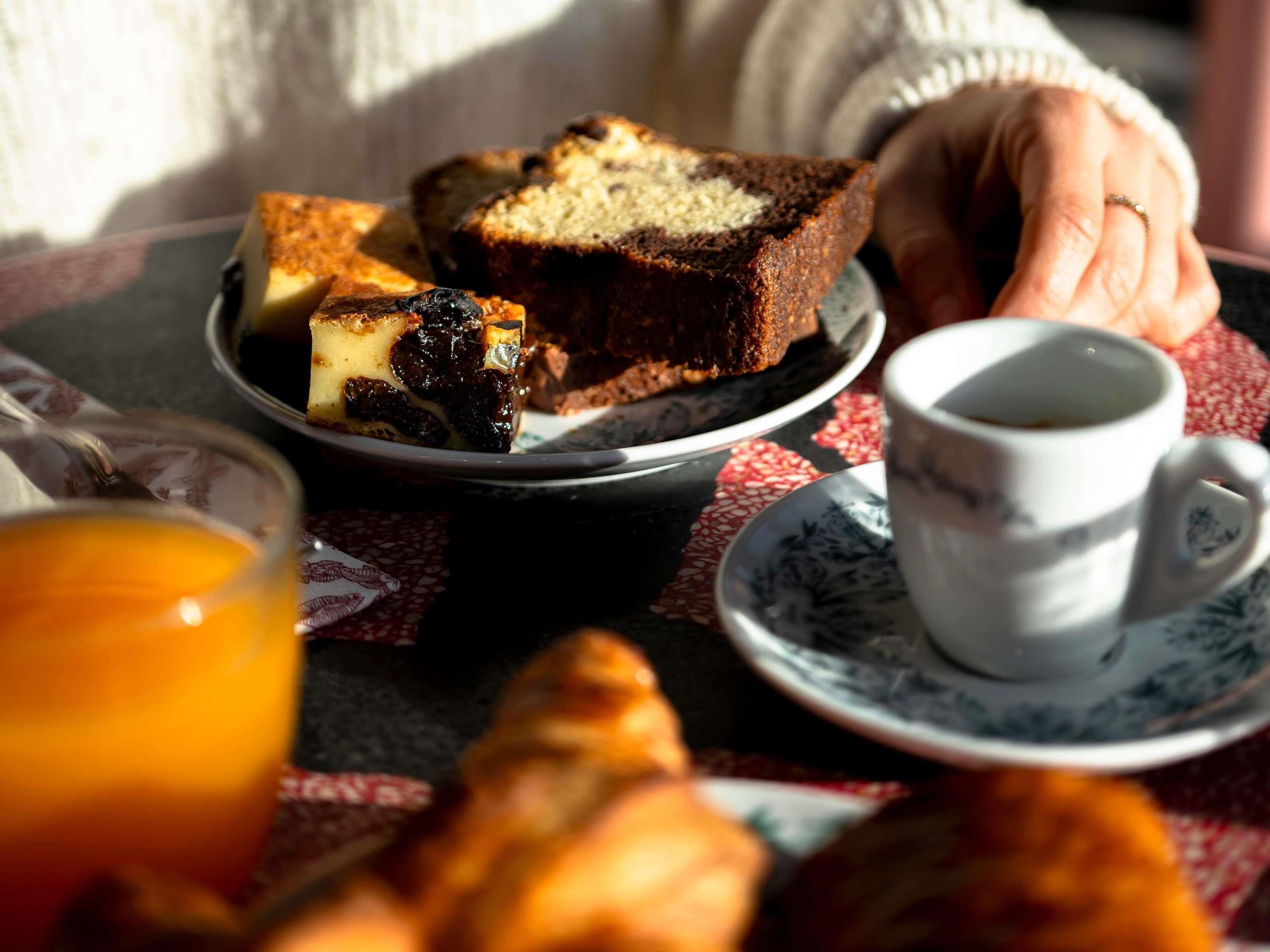 A breakfast setting with a plate of food, a cup of coffee, and a glass of orange juice.