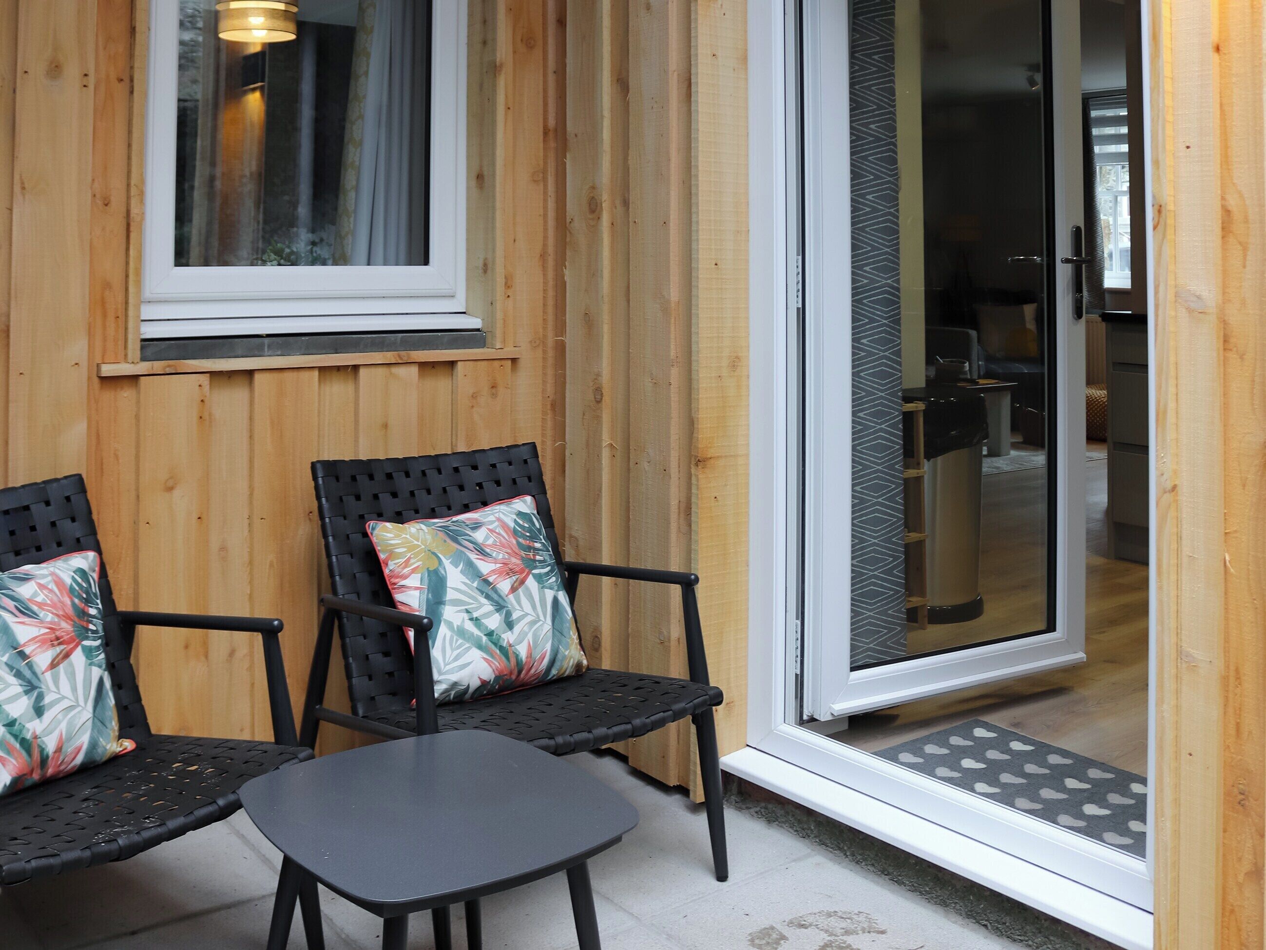 Een houten gevelwand met een schuifdeur die leidt naar een keuken.