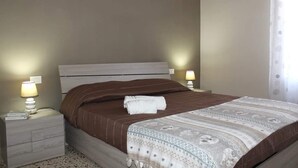 A bedroom with a bed, nightstands, and lamps. - 2 Bedroom Apartment in Sambuca di Sicilia (Sambuca di Sicilia)