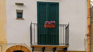 A building with a balcony, a small window, and a door with a number. - 2 Bedroom Apartment in Sambuca di Sicilia (Sambuca di Sicilia)