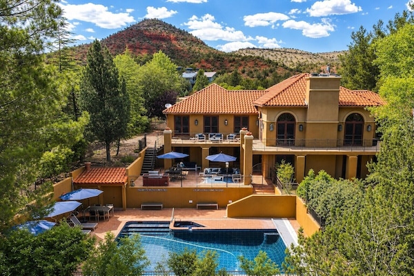 Creekside estate with a resort-style pool, multiple terraces, and views