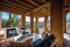 An outdoor patio with wooden furniture and a view of the surrounding landscape.