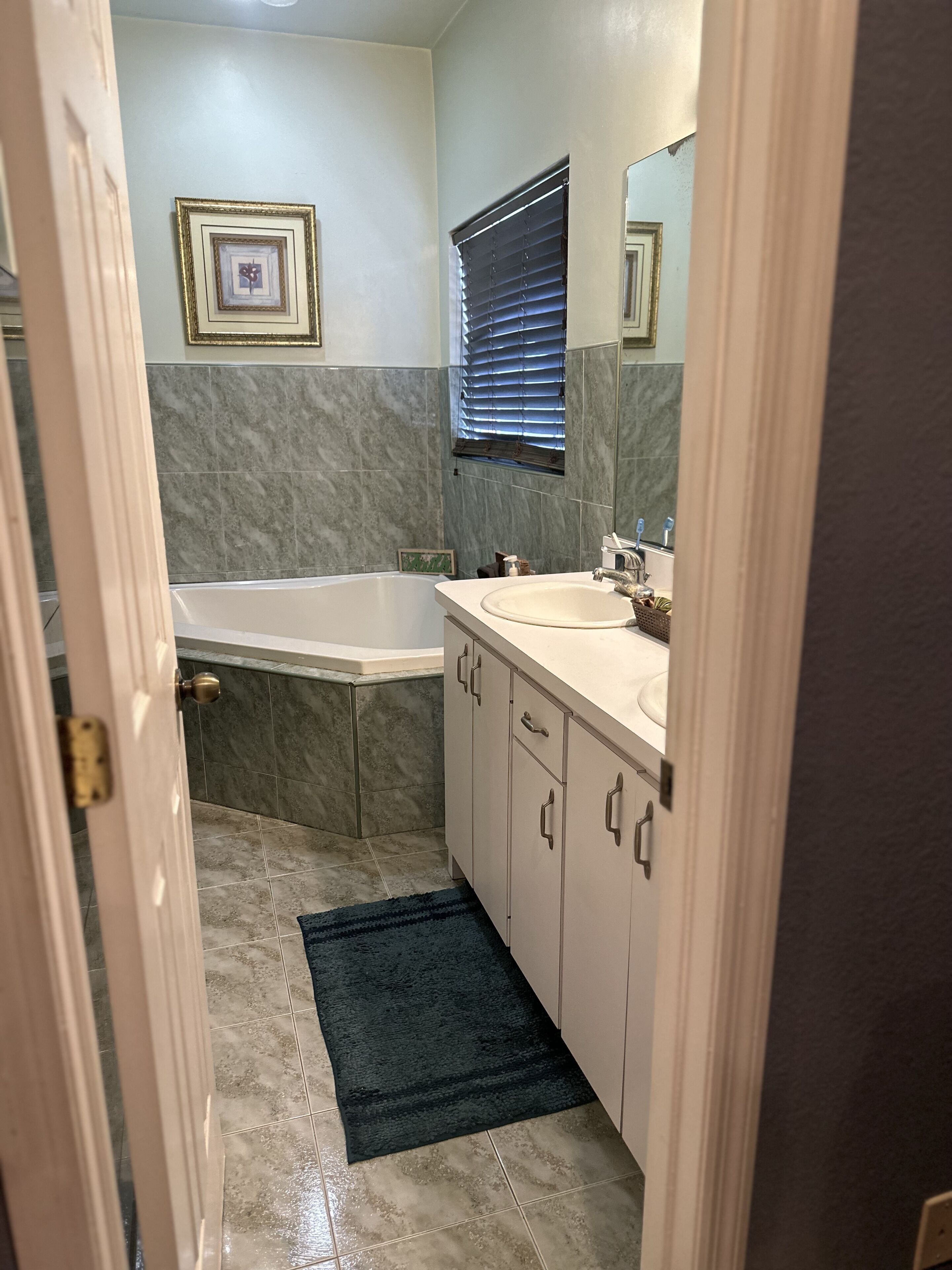 Une salle de bain avec une baignoire, un lavabo et un miroir.
