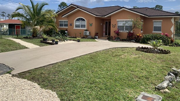 A two-story house with a red roof, a front porch, and a well-maintained lawn. - Quiet Haven  (Freeport)