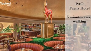 Un restaurant avec des tables rondes et des banquettes, un coin bar et une statue de cheval décorative.