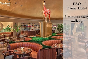 A restaurant with round tables and booths, a bar area, and a decorative horse statue.