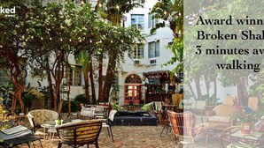 An outdoor seating area with various chairs and tables, surrounded by trees and plants. - 2 BEDROOM ON THE BEACH ! (Miami)