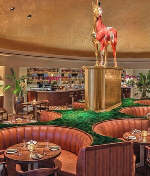 A restaurant with leather booths, a bar area, and a central decorative sculpture. - Newly remodeled apartment only 1 min to the beach! (Miami Beach)