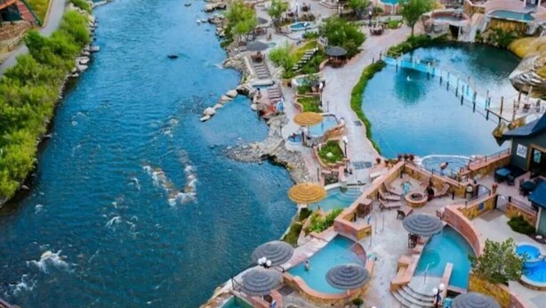 Un complexe hôtelier doté de plusieurs piscines, d’une rivière et d’un pont.