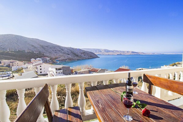 Enjoy a meal on the terrace with a view of the sea and distant hills.