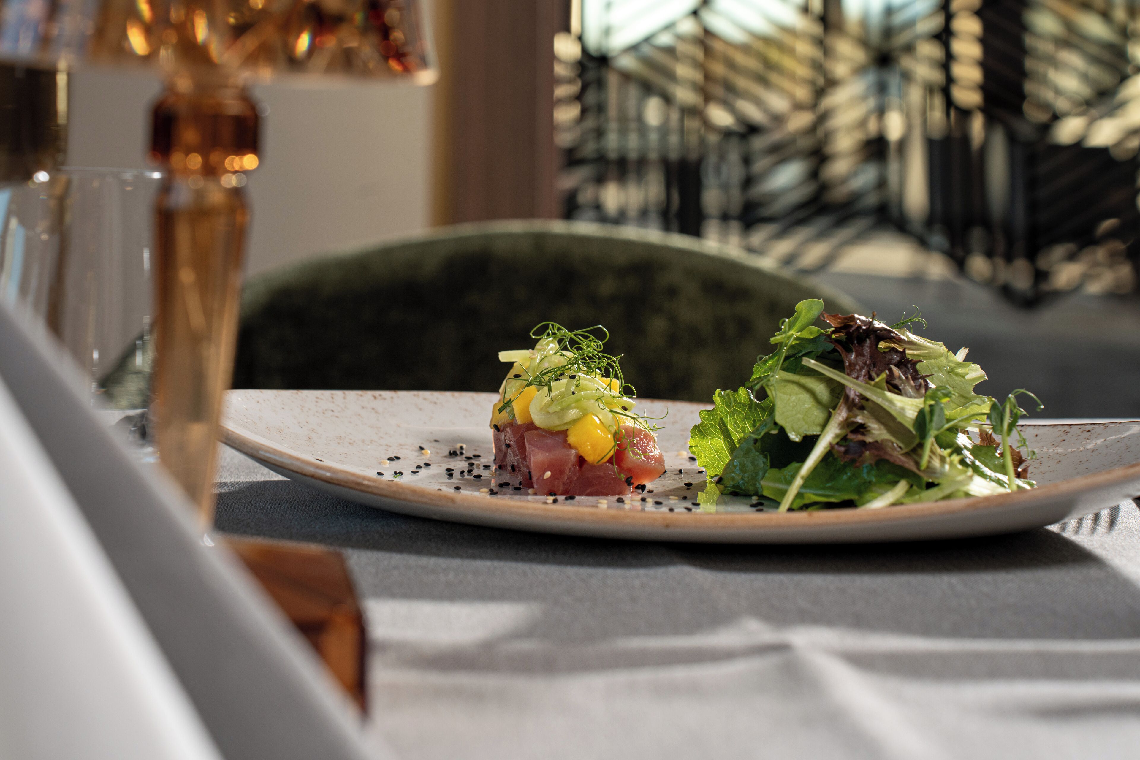 A plate with a seafood dish and a salad on a table in a restaurant.