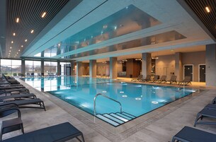 Una piscina techada, una piscina al aire libre de temporada, sombrillas