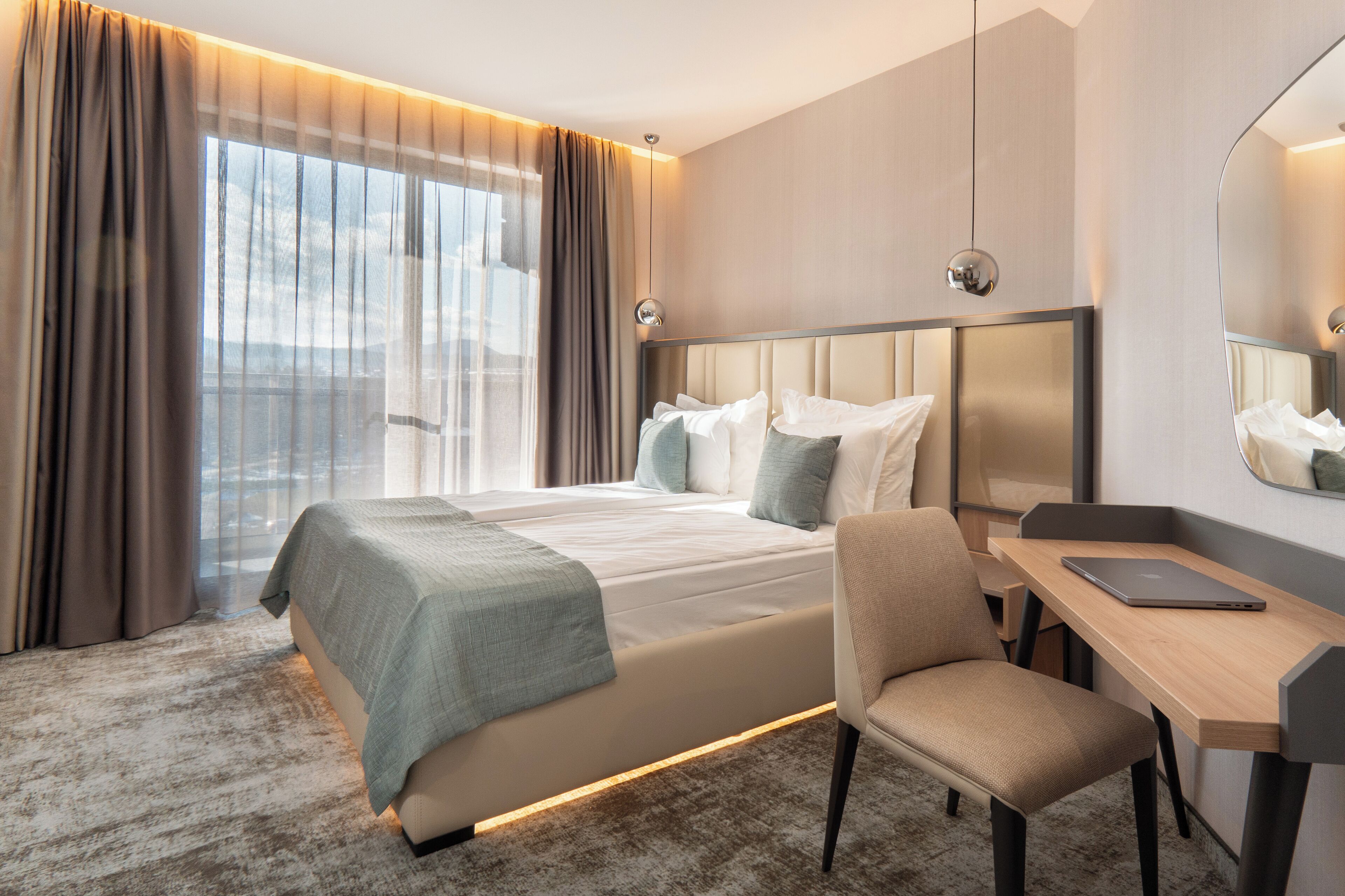 Una habitación de hotel moderna con una cama grande, un escritorio y una silla.
