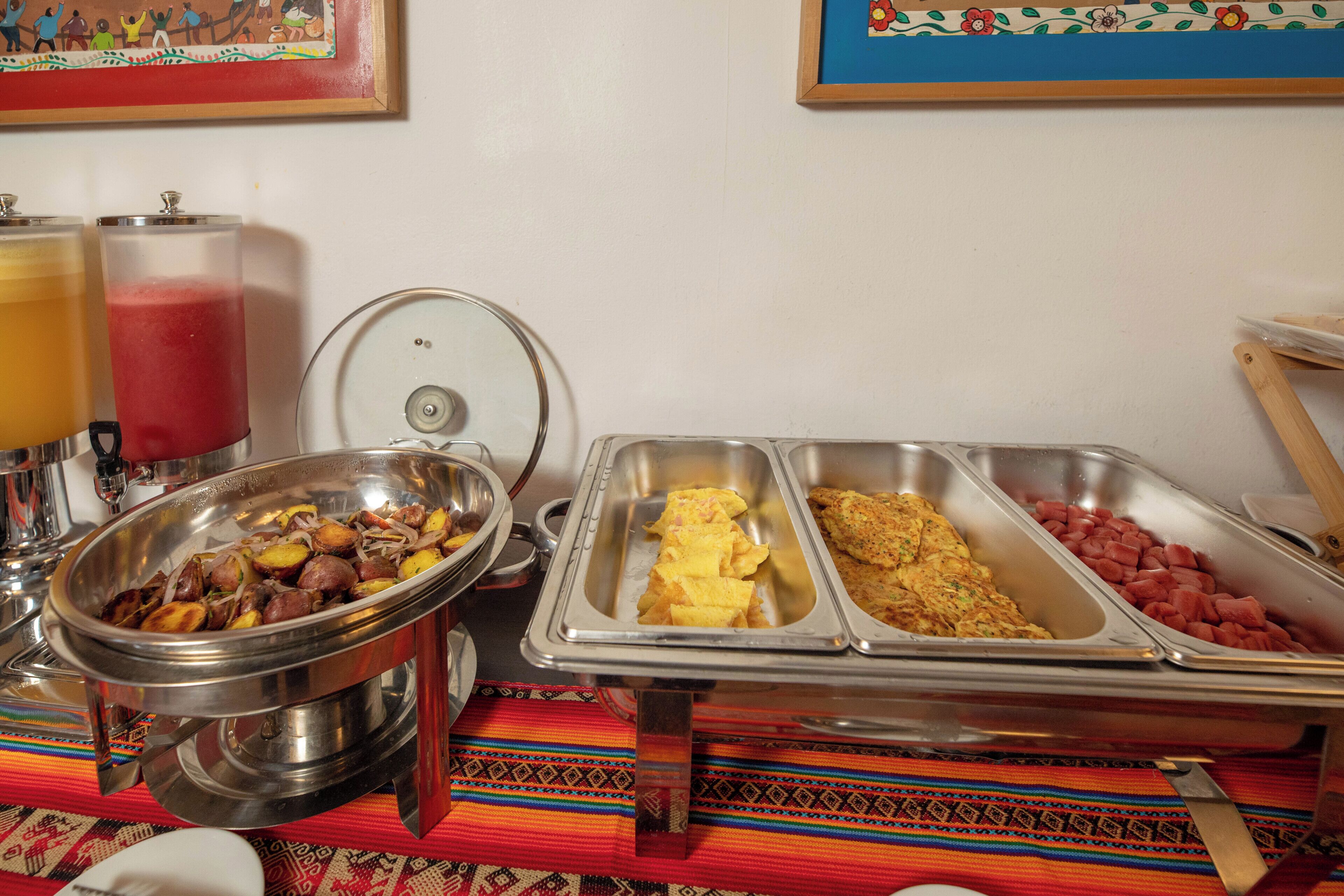 Een buffet met diverse gerechten, zoals aardappelen, eieren en worst.