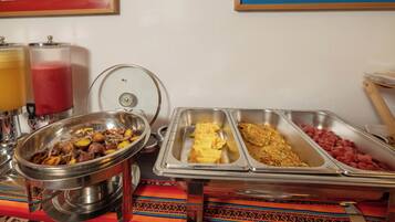 Een buffet met diverse gerechten, zoals aardappelen, eieren en worst.