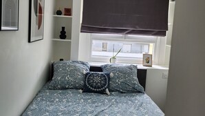 A bedroom with a bed, a hanging light fixture, a window with blinds, and wall art. - Sublime Appartement Proche de Paris et La Défense Arena (Courbevoie)