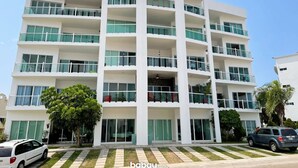 A multi-story hotel with balconies, large windows, and a central entrance.