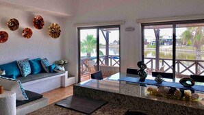 Una cocina moderna con un ventanal grande, una zona de estar con sofá y vistas a un cuerpo de agua.