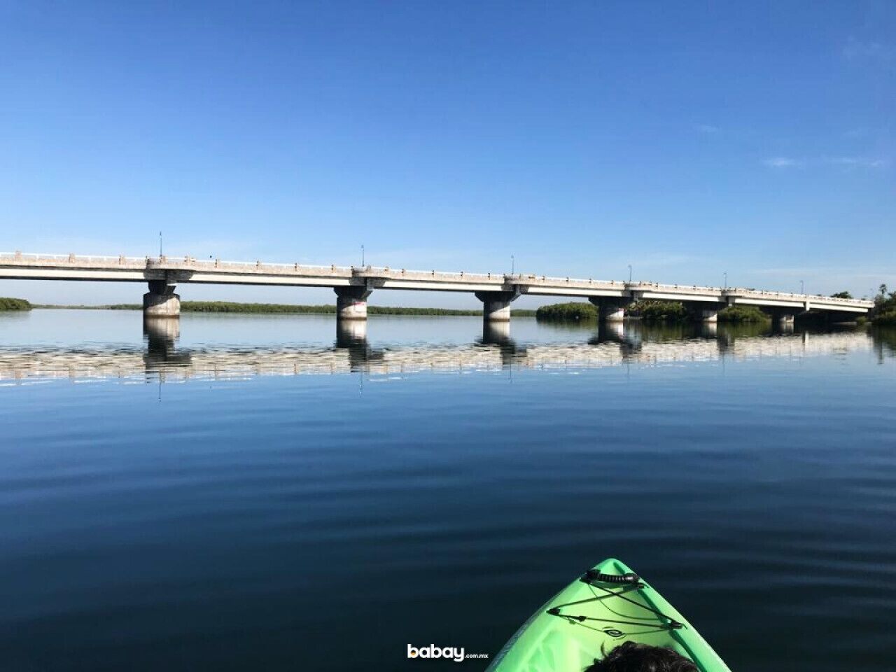 Ein ruhiger Fluss mit einer Brücke im Hintergrund.