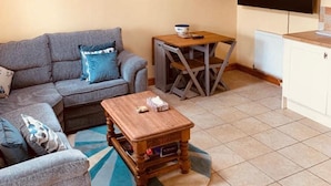 Un salon confortable avec un canapé, une table basse et une table à manger.