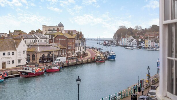 A riverside town with historic buildings, a marina with boats, and a bridge in the distance. - 5 bedroom accommodation in Weymouth (Weymouth)