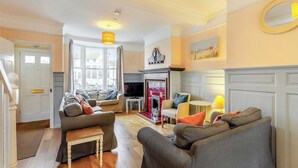 A living room with a fireplace, a television, and a sofa. - 5 bedroom accommodation in Weymouth (Weymouth)