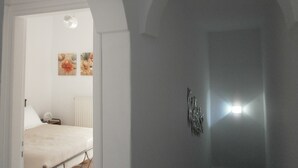 A bedroom with a bed, a nightstand, and wall art.
