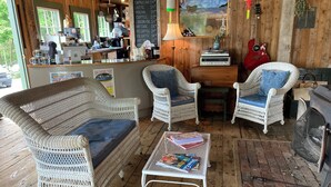 Ein gemütliches Café mit Korbmöbeln, einer Kaffeebar und rustikalem Holzinventar.