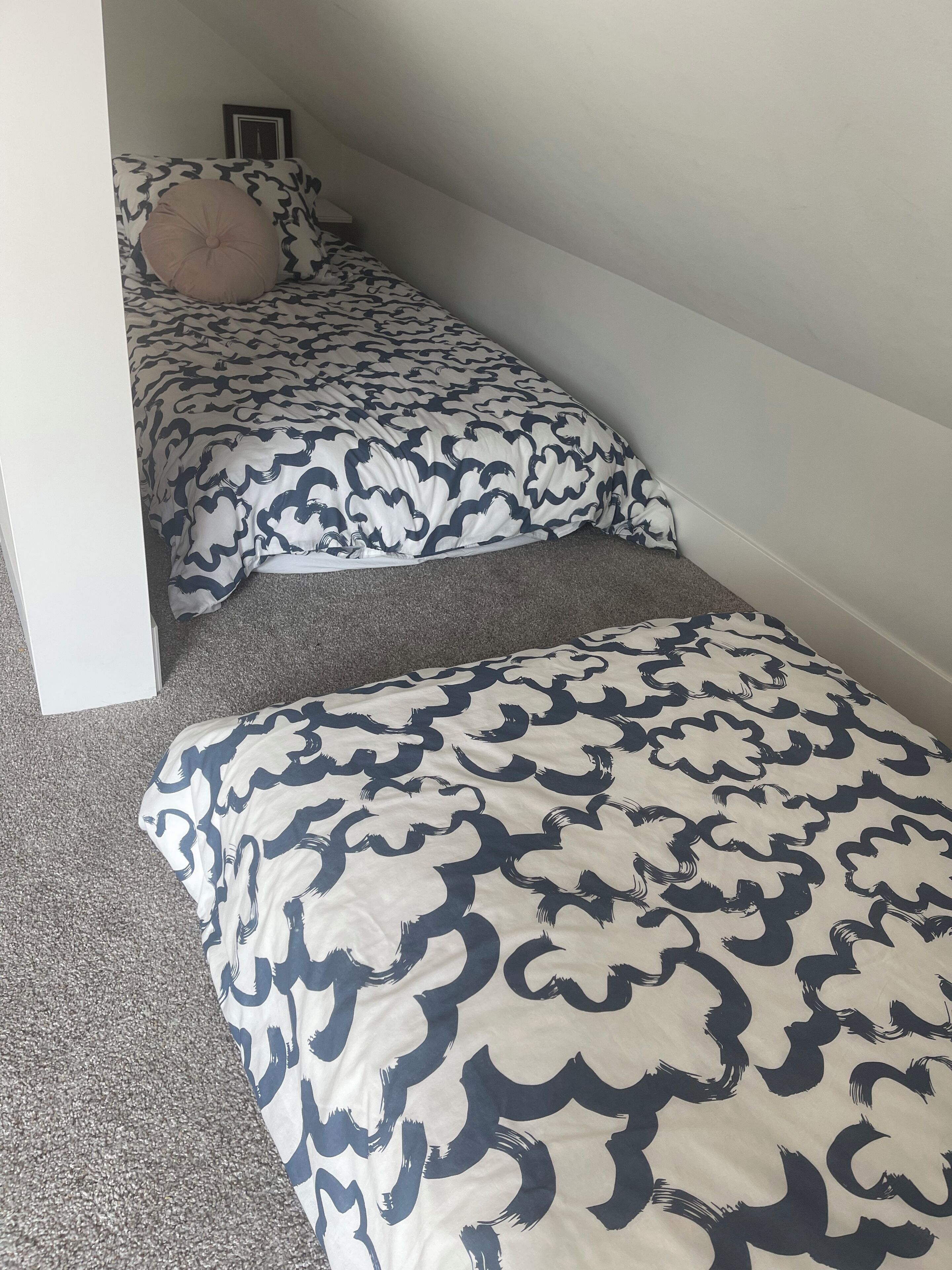 Ein Schlafzimmer mit zwei Betten, jeweils mit einem gemusterten Überwurf.