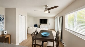 A modern kitchen with a dining area, a ceiling fan, and a view of the living room. - Spacious South Bay Condo (Torrance)