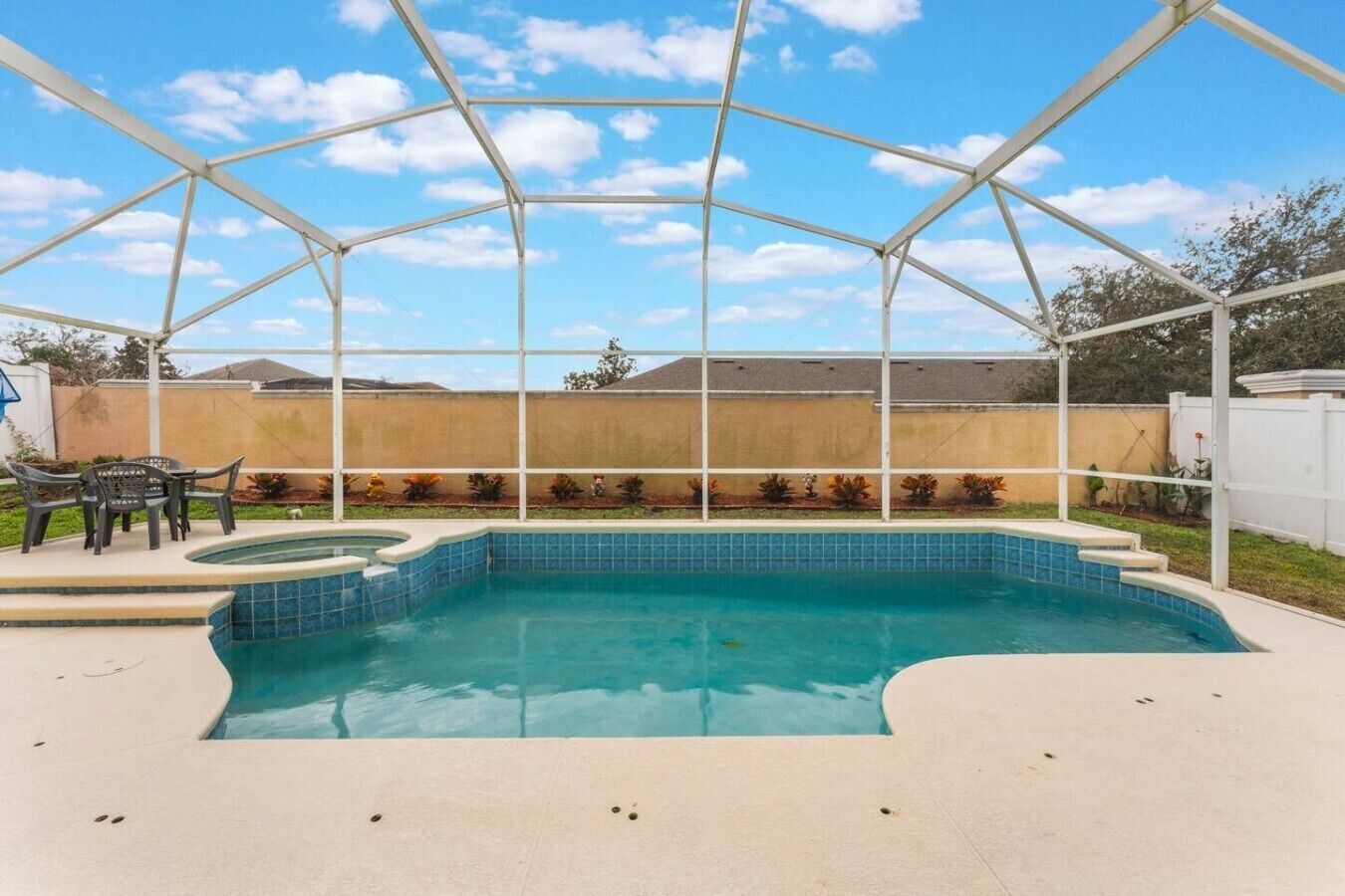 Une piscine extérieure couverte, dotée d’un patio et offrant une vue sur le jardin arrière.