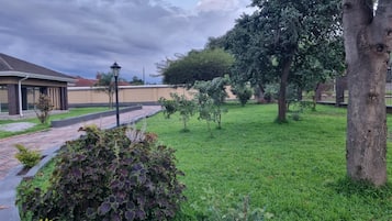 Stroll through lush gardens and paved walkways to the charming building with a brick facade.