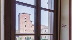 A window with a view of a brick building and a courtyard. - AGRITURISMO CASTELLO BECCARIA (Pieve del Cairo)