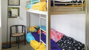 A bunk bed room with a chair, a framed picture, and a small table. - This cosy cottage is an ideal base for you and your dogs. (St Just)