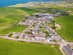 An aerial view of a residential area with houses, roads, and fields.