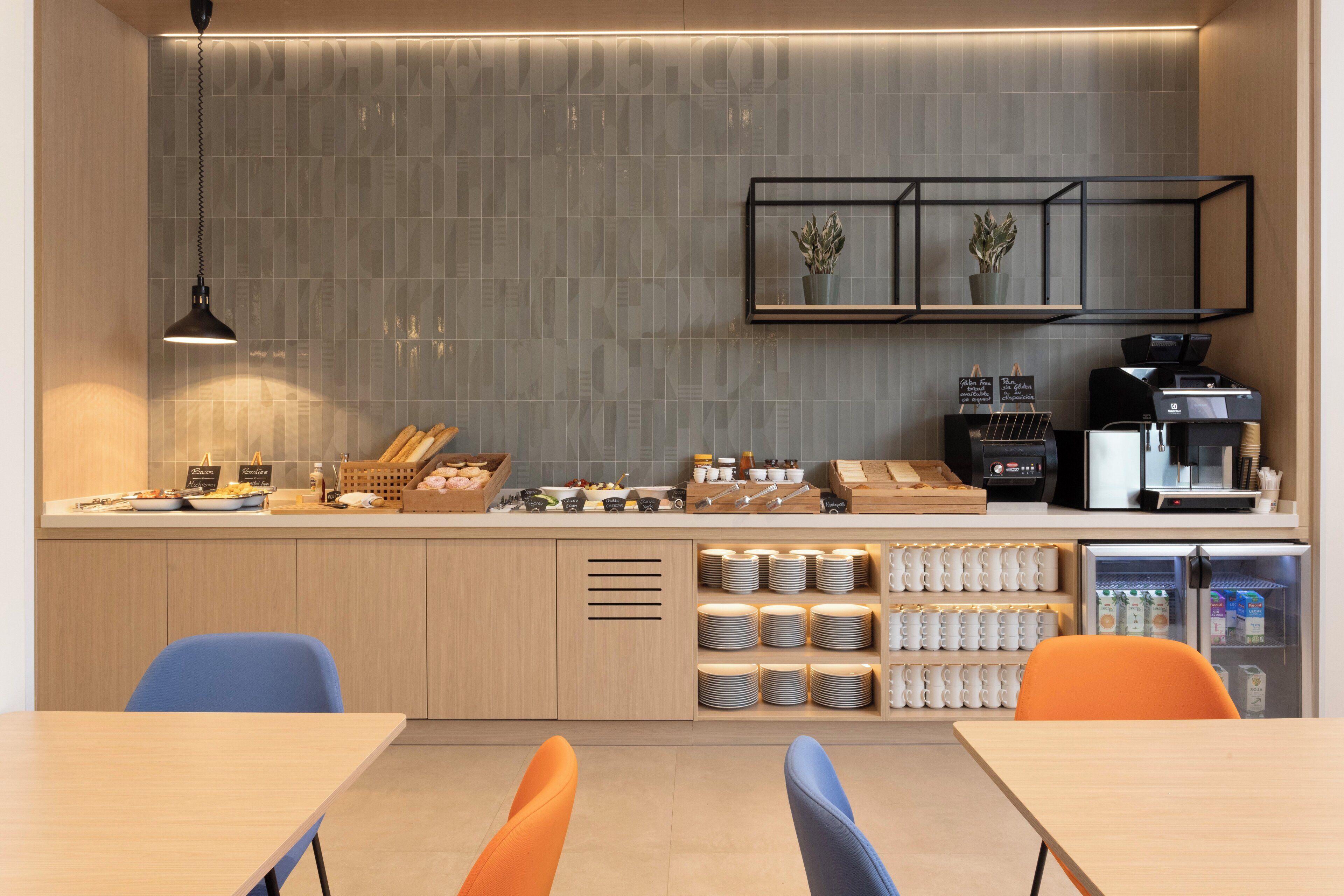Une cuisine moderne équipée d’un plan de travail, d’une machine à café et d’un réfrigérateur.