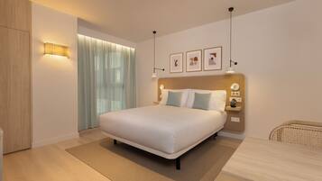Una habitación de hotel moderna con una cama grande, mesitas de noche, un escritorio y una ventana con cortinas.