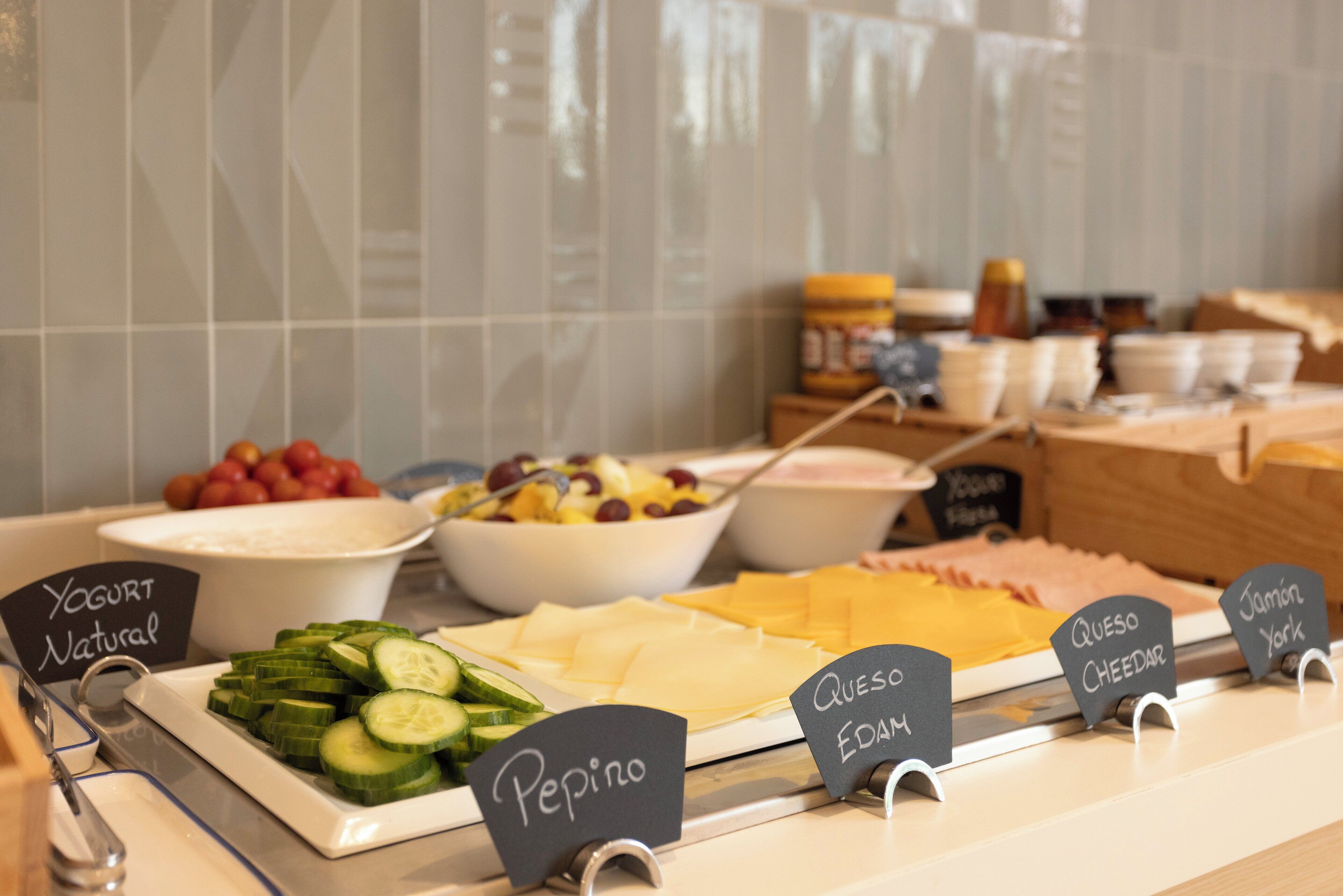 Ein reichhaltiges Buffet mit ausgewiesenen Speisen, darunter Joghurt, Käse und verschiedene Salate.