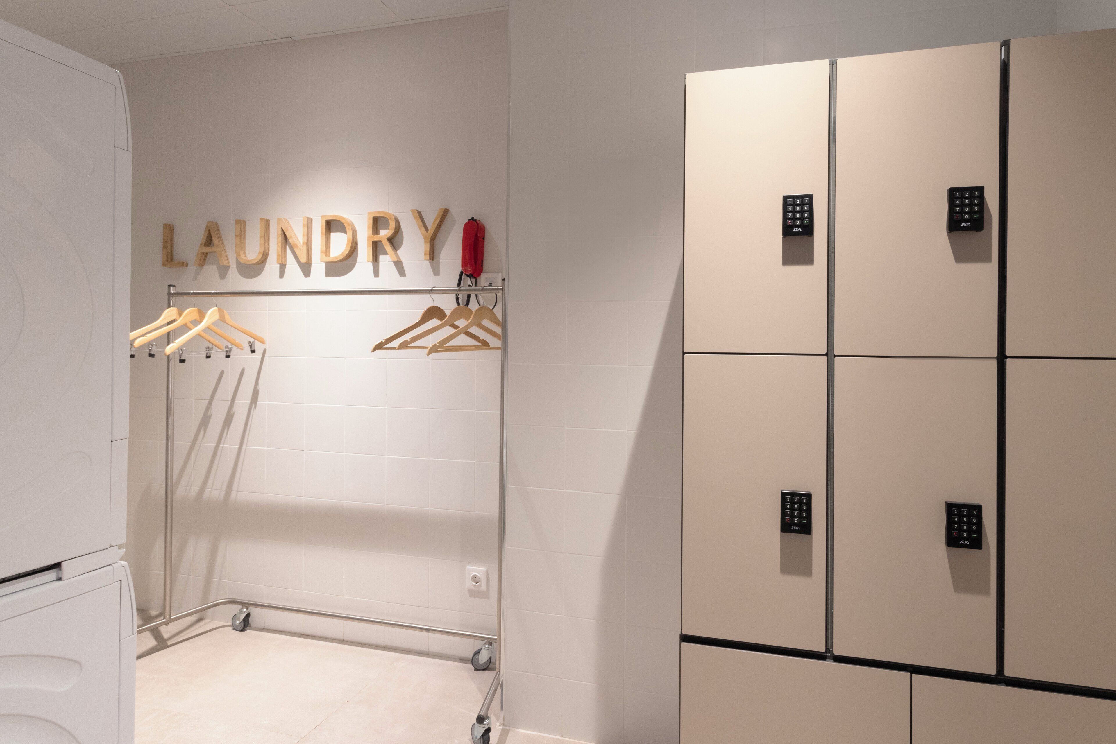 Un área de lavandería con perchas de madera y un letrero en la pared que dice "LAUNDRY".