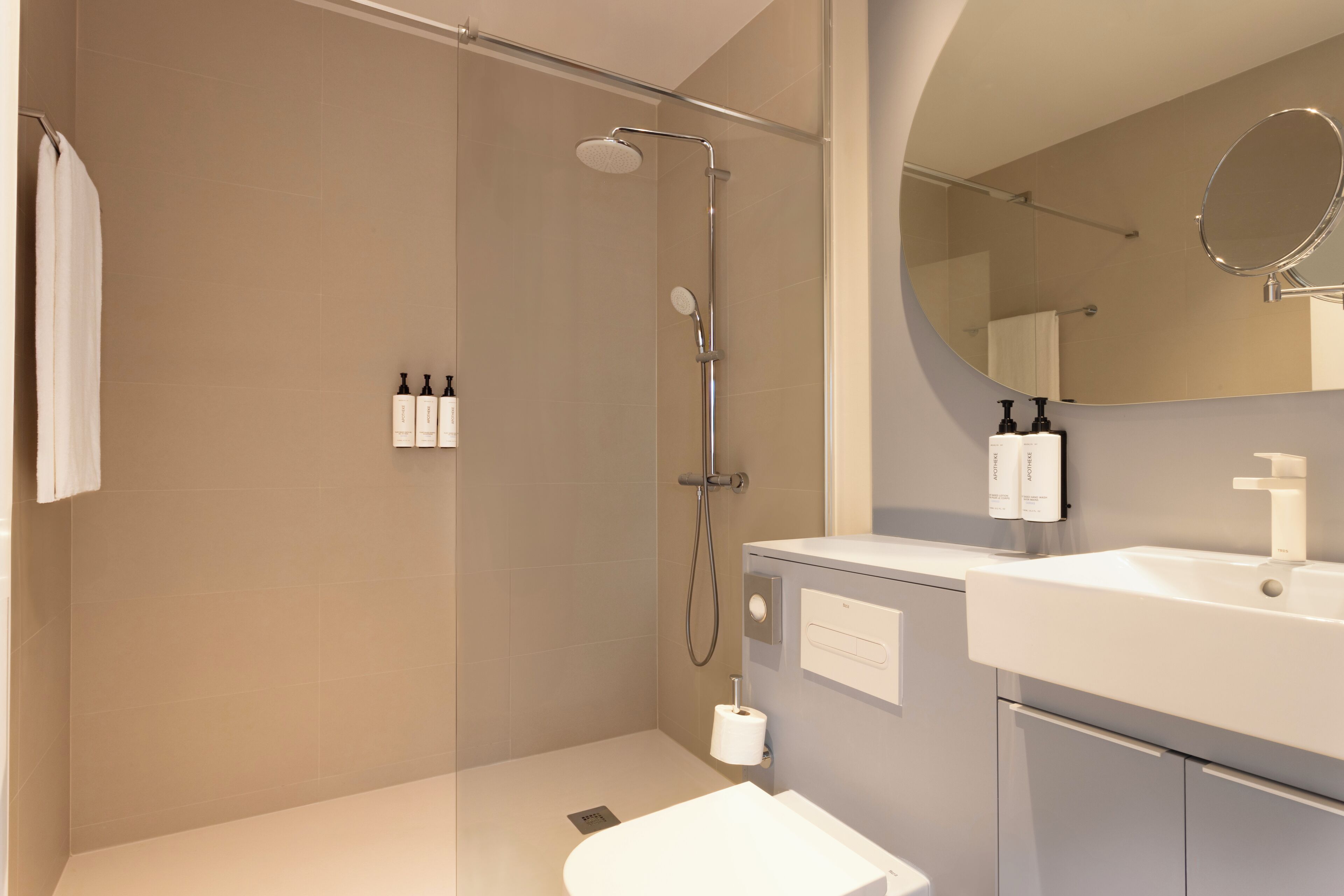 A modern bathroom with a shower, sink, and mirror.