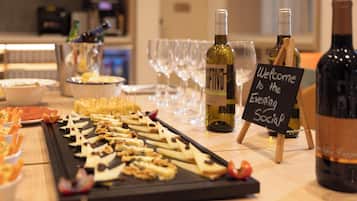 Una mesa de buffet con diversos alimentos y botellas de vino, un cartel que dice "Welcome to the Evening Social".