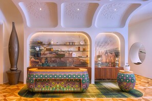 A modern interior with a central seating area, a decorative vase, and a wall with a cityscape mural.