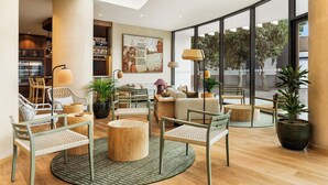 A modern interior with a seating area, large windows, and a bar. - Holiday Inn Beja by IHG (Beja)