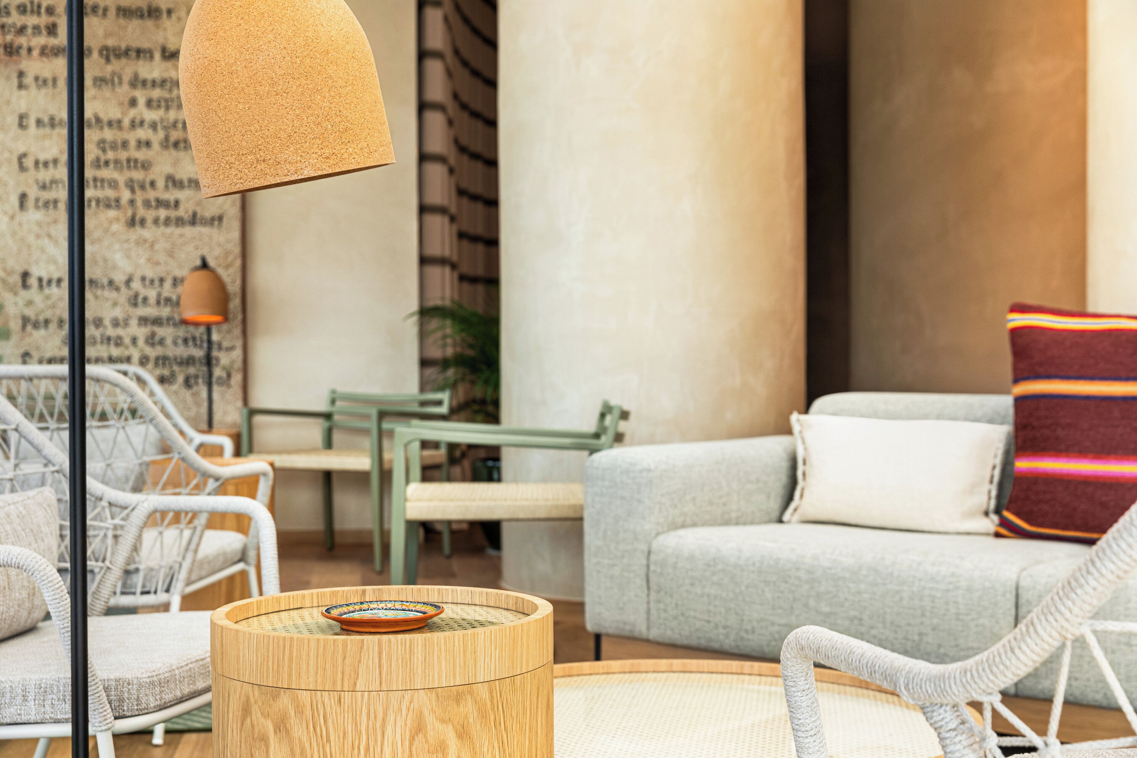 Una sala moderna con muebles de mimbre, una mesa redonda de madera y un sofá gris.