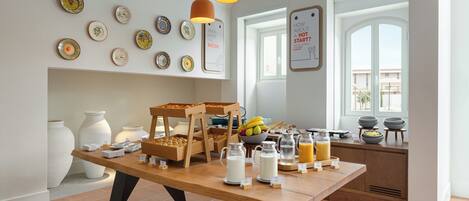 Ein reichhaltiges Frühstücksbuffet mit verschiedenen Speisen und dekorativen Tellern an der Wand.