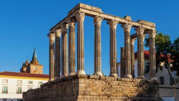 A classical structure with multiple columns, likely a historical monument, set against a clear blue sky.