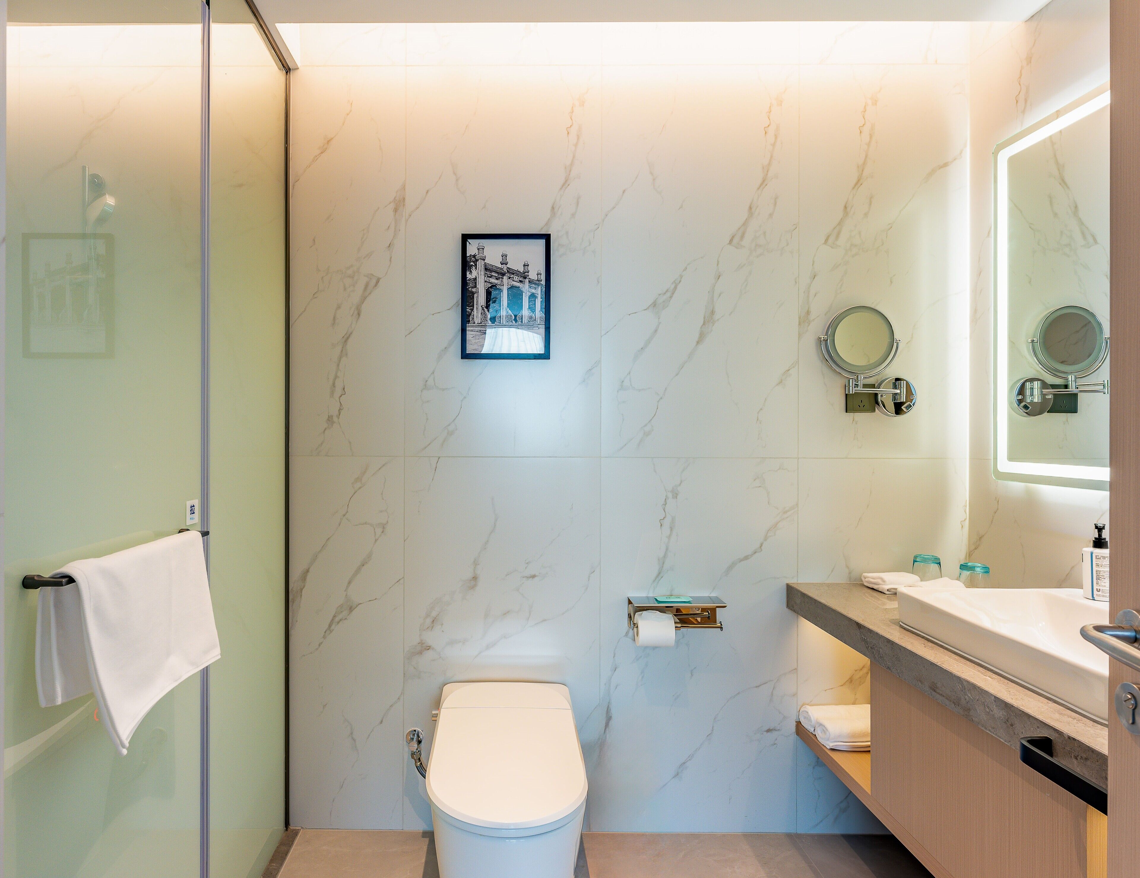 A modern bathroom with a toilet, a sink, and a shower area.