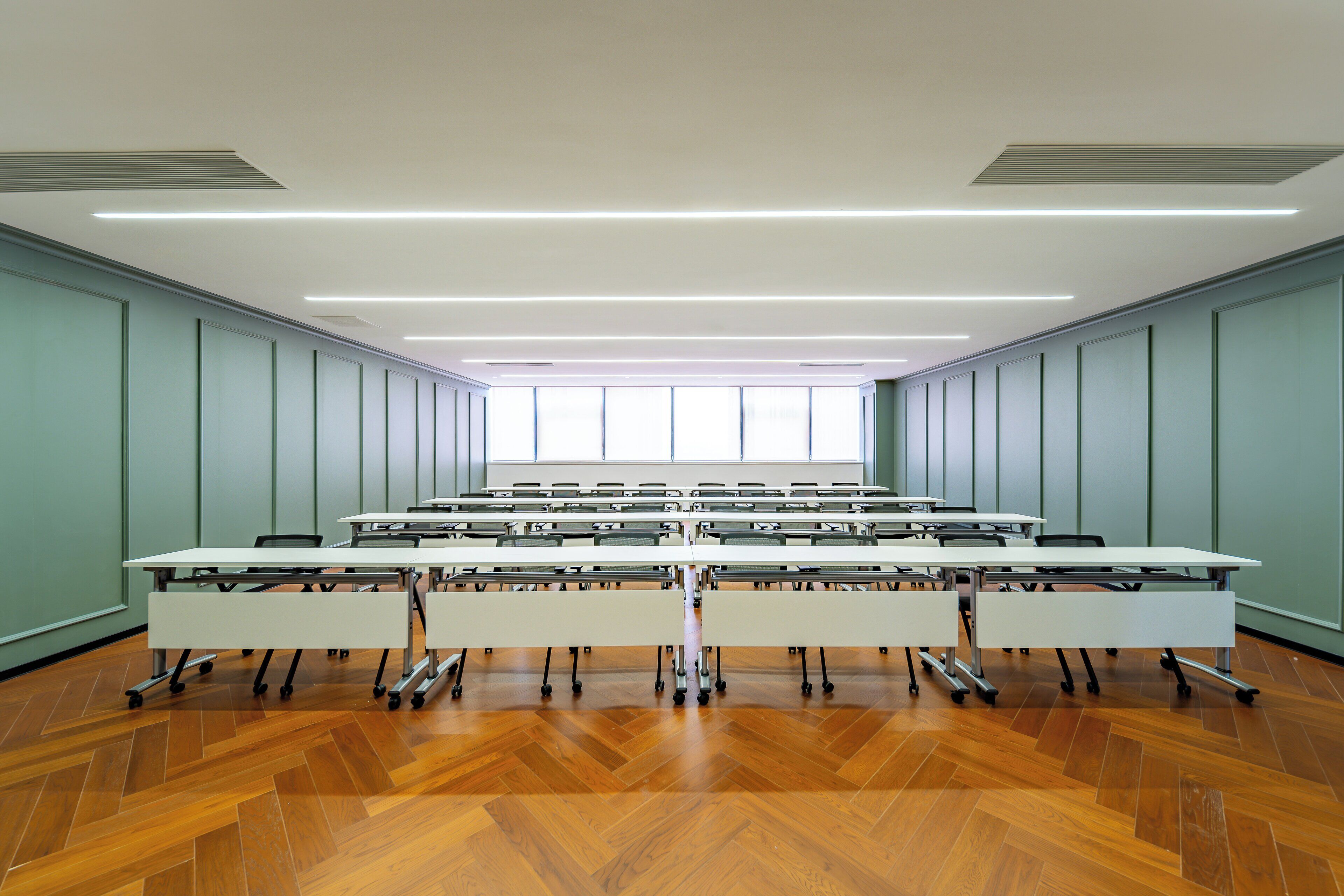 A conference room with a long table, chairs, and a large window.