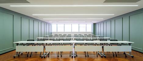 A conference room with a long table, chairs, and a large window.